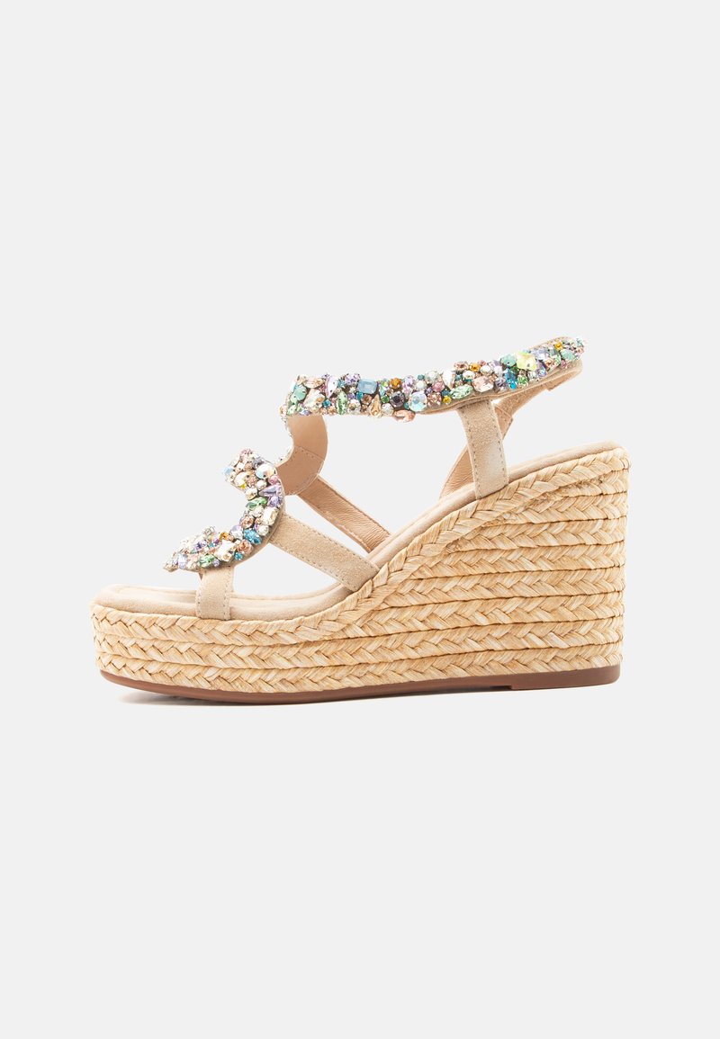 Sandale compensée beige avec semelle plateforme tressée et plusieurs lanières ornées de pierres précieuses multicolores.