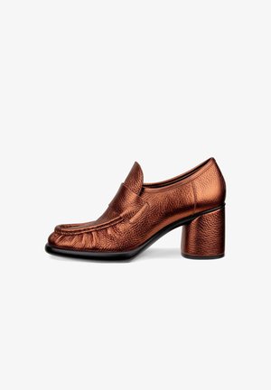 Bruna läderloafers med klack och texturerad yta, rund tå och en 4 cm blockklack. Har en diskret sömdetalj över framtill.