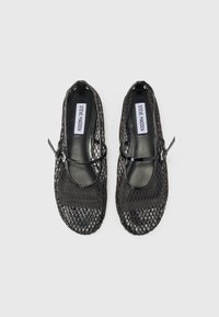 Des ballerines noires en mesh avec un bout arrondi, dotées d'une fine sangle sur le coup de pied et d'une semelle intérieure noire lisse et brillante.