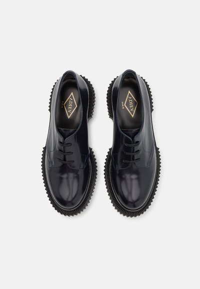 Pantofi din piele bleumarin cu un finisaj lucios, având un design cu șireturi, vârf rotund și o talpă groasă, cu zimți din cauciuc. Logo auriu în interior.
