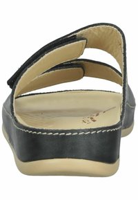 Sandal in pelle nera con strap posteriore, lati aperti e soletta in beige testurizzata. Presenta cuciture bianche lungo la suola.