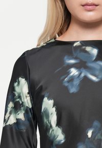 Black satin dress with long sleeves, featuring a floral pattern in shades of blue and green, smooth texture, rounded neckline.