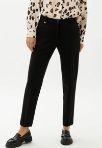 Zwarte op maat gemaakte broek van soepel materiaal, met een slim fit, zijzakken en een subtiele zilveren accent op de tailleband.