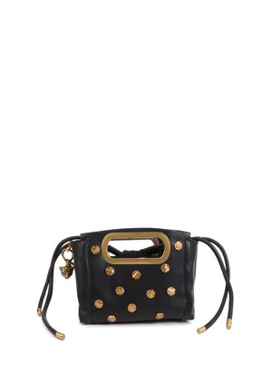 Bolso de cuero negro con detalles de tachuelas doradas, asa rectangular, cierre con cordón y un distintivo charm adjunto.