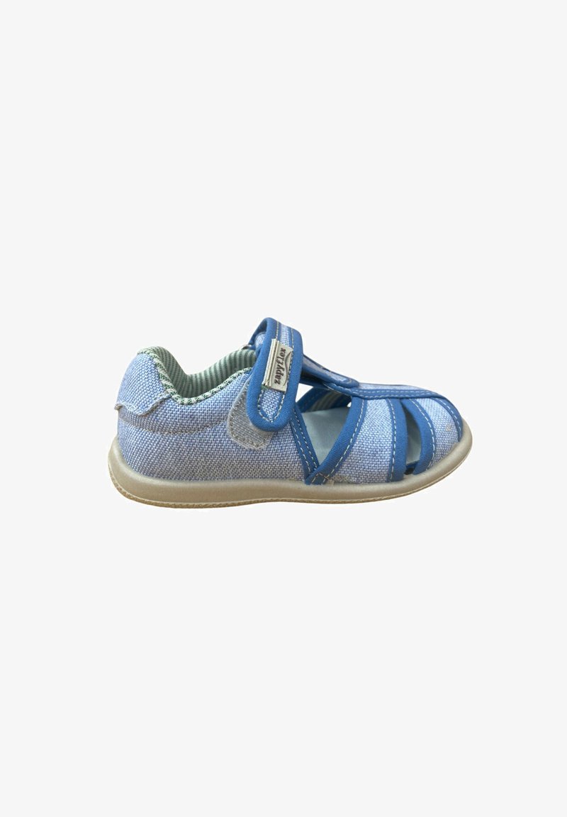 Sandalía para niño pequeño de color azul claro con cierre de velcro, diseño de punta abierta y suela beige, mostrada de perfil sobre un fondo blanco.