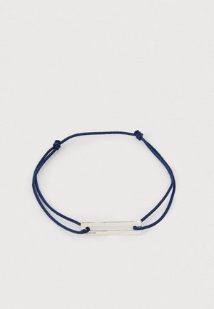 Marineblaue verstellbare Schnurarmband mit einer rechteckigen silbernen Metallplatte, die durch zwei Löcher gefädelt ist.