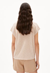 Pasiasty, krótki top z rękawem w jasnym beżu i kremowym kolorze, z okrągłym dekoltem i luźnym krojem. Pokazany z tyłu z gładką fakturą.