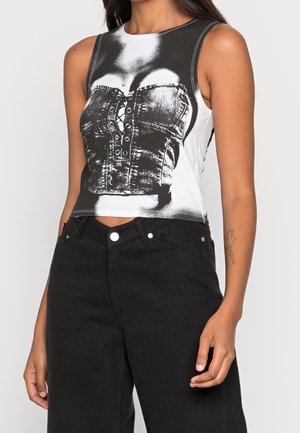 Haut court sans manches présentant un motif noir et blanc d'un corset en denim avec des détails à boutons. Le tissu est lisse et ajusté.
