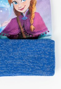 Cappello per bambini con design di personaggio, realizzato in tessuto viola, con bordo a coste blu e illustrazione dettagliata del volto. Texture morbida e lavorata a maglia.