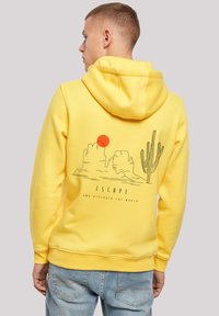 Yellow hoodie with a drawstring hood, featuring a graphic of mountains, a sun, and a cactus on the back in black and red. Casual fit.