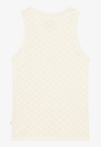 Sømløs kremfarget tanktop uten ermer med ribbestruktur, små mønstrede utskjæringer og rund utringning.