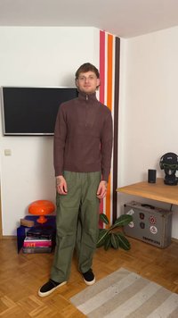 Pruun soonik, millel on ribad ja luku kaelus, rohelised cargo-püksid, mustad kingad. Tuba, mille seinal on värvilised ribad, taim ja sisustus koos aktsentdetailidega.