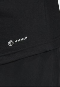 Musta urheilupaita, jossa on sileä ja pehmeä rakenne; sisältää valkoisen "AEROREADY"-logon ja maapallon ikonina. Yksinkertainen muotoilu ja istuva malli.