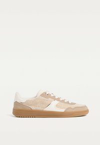 Sneaker sportive beige con tomaia in tessuto, dettagli in camoscio e suola in gomma. Presentano una chiusura con lacci e pannellature testurizzate.