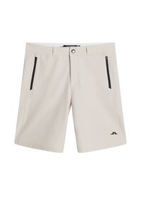 Ljust beige shorts tillverkade av mjukt tyg, med två fickor med dragkedja på sidorna, en enkel knappstängning och en logotyp på nedre vänstra sidan.