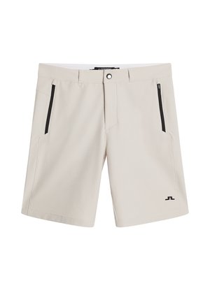 Shorts beige chiaro realizzati in morbido tessuto, dotati di due tasche laterali con zip, chiusura con un bottone e un logo in basso a sinistra.