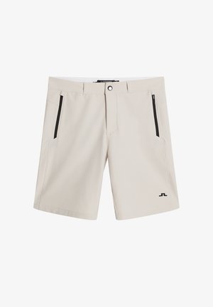 Helle beige Shorts aus weichem Stoff, ausgestattet mit zwei seitlichen Reißverschlusstaschen, einem einzigen Knopfverschluss und einem Logo auf der unteren linken Seite.