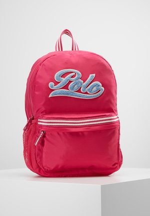 Czerwony plecak z niebieskim logo "Polo", przednia kieszeń na zamek z białym paskiem, boczna siateczkowa kieszeń oraz różowa pętelka na uchwycie.