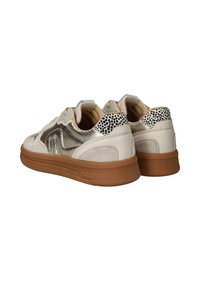 Beige suède en metallic sneakers hebben gevlekte accenten op de hiel, met een getextureerde gum zool en gestikte details.