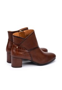 Bottines marron en cuir lisse avec un panneau en relief crocodile, un petit talon carré et une fermeture éclair à l'arrière.