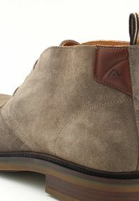 Stivale alla caviglia in suede marrone con finitura texturizzata, dettagli in pelle e suola in gomma con colori sovrapposti. Fascia laterale per una facile calzata.