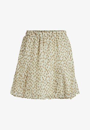 Jupe courte évasée en tissu léger crème avec des pois marron. Présente une taille élastique et un ourlet à volants.