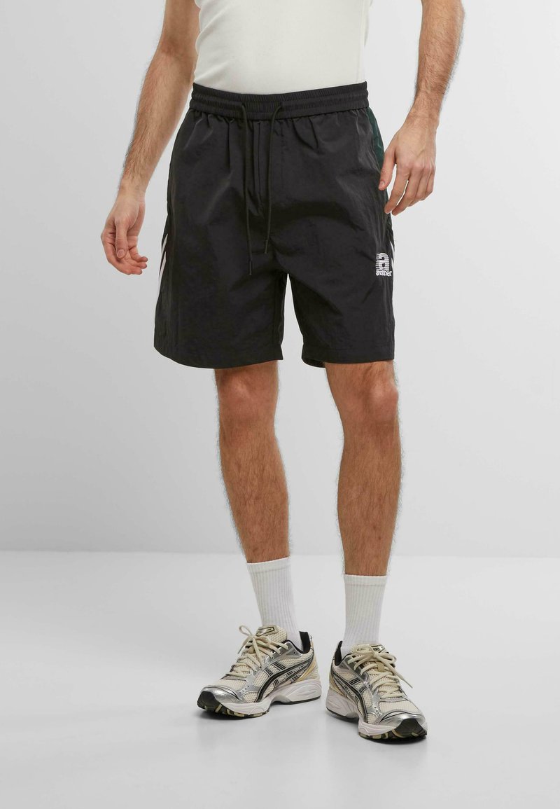 Sorte atletiske shorts med elastisk talje og snøre. Har sidelommer og et hvidt logo nederst til højre.