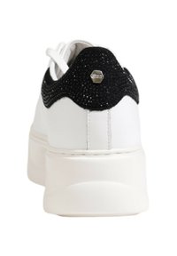 Sneaker bianco con un tallone glitterato nero, materiale in pelle liscia, suola spessa e accento metallico esagonale sul retro.