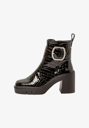 Schwarze Lack-Stiefelette mit Krokodilprägung, quadratischer Zehenform, hohem Blockabsatz und silberner Schnallenakzent an der Seite. Mit strukturierter und glatter Oberfläche.