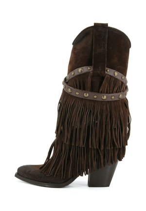 Stivale da cowboy in suede marrone scuro con tacco impilato, frangia a strati e cinturino in pelle con borchie intorno alla caviglia.