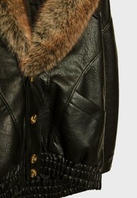 Giubbotto di pelle nera con colletto in pelliccia marrone, chiusura con bottoni, tasche laterali e orlo arricciato per un look aderente.
