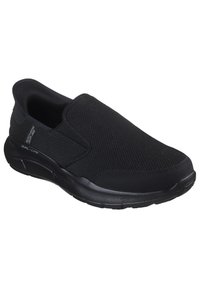 Scarpe slip-on nere realizzate in tessuto testurizzato con suola in gomma liscia, caratterizzate da un design minimalista e pannelli laterali elasticizzati per una facile calzata.