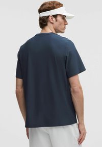 Námornícky krátky rukáv športového trička z hladkého materiálu s jemnou vertikálnou textúrou, s uvoľneným strihom a zaobleným lemom.