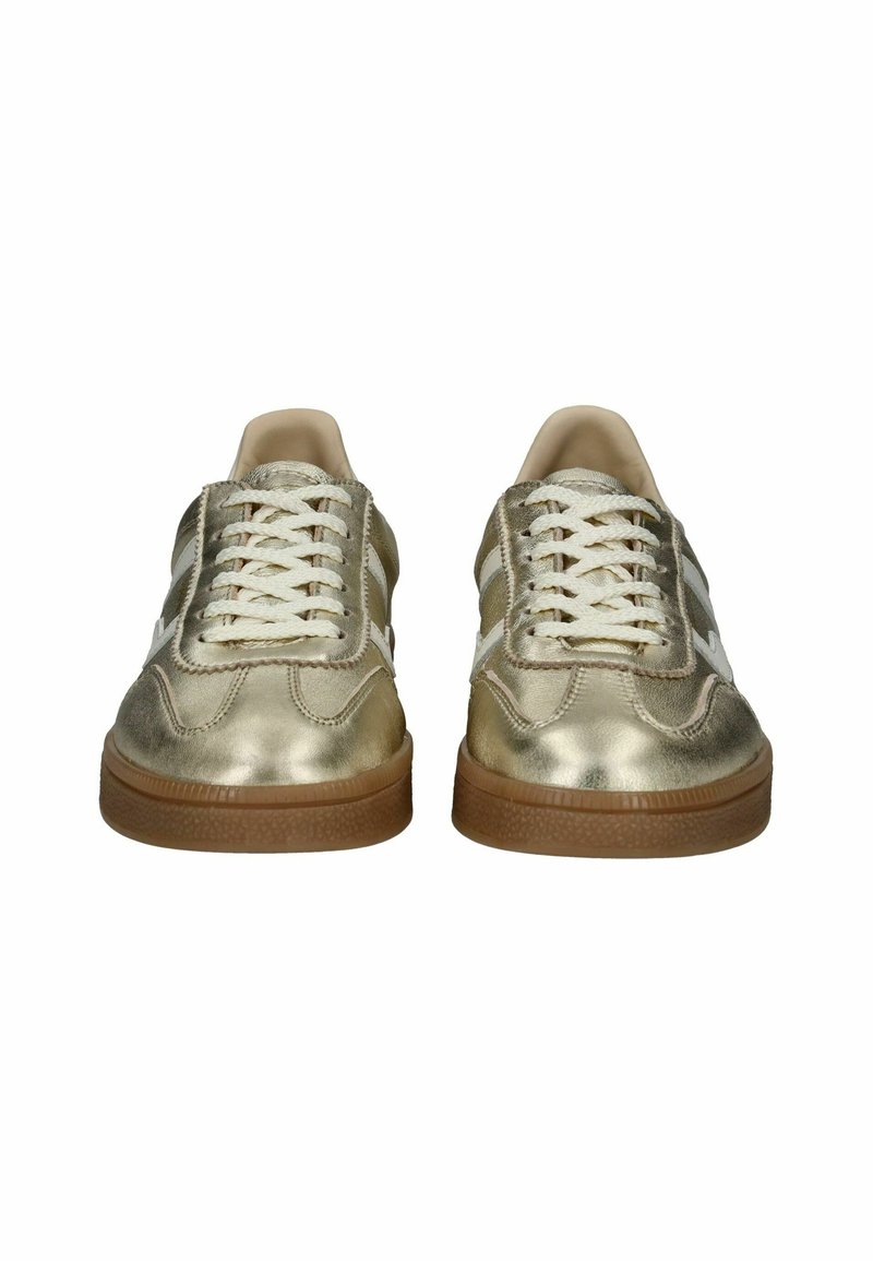 Baskets dorées métalliques avec des lacets blancs, texture lisse, forme arrondie, bandes latérales contrastées et semelle extérieure en caoutchouc marron.