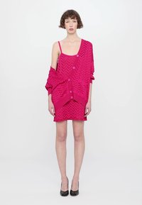 Abito lavorato a maglia rosa con motivo a zigzag, dotato di un cardigan sovrapposto con bottoni, maniche corte e silhouette aderente.