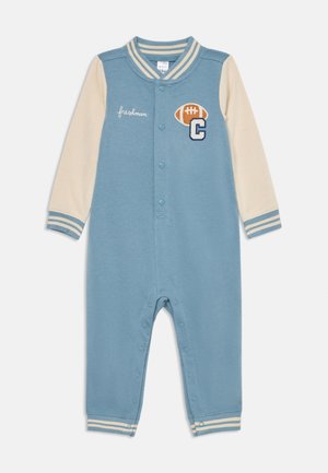 Grenouillère bébé bleu et crème avec boutons-pression, poignets et col rayés, patch de football et texte "freshman" sur la poitrine.