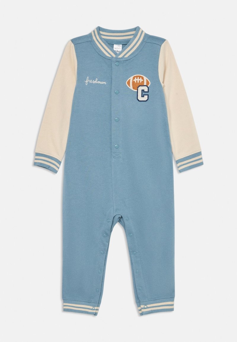 Grenouillère bébé bleu et crème avec boutons-pression, poignets et col rayés, patch de football et texte "freshman" sur la poitrine.