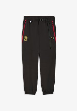 Pantaloni sportivi neri con polsini elastici, tasche laterali con zip rosse, cintura nera, logo AC Milan sulla coscia sinistra e logo Puma sulla coscia destra.
