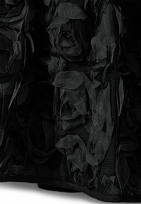Crna tkanina s trodimenzionalnim uzorcima ruža izrađenim od mekog, teksturiranog materijala; prozirni dijelovi s slojevitim, preklapajućim laticama.