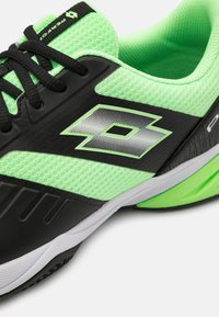 Pantofă sport neagră și verde neon, cu partea superioară din plasă, accente texturate și o talpă ușoară, având un logo proeminent pe lateral.