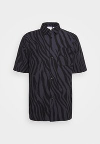 Short-sleeved black shirt with a zebra print pattern, featuring a button-up front and a single chest pocket. Made from a smooth fabric.