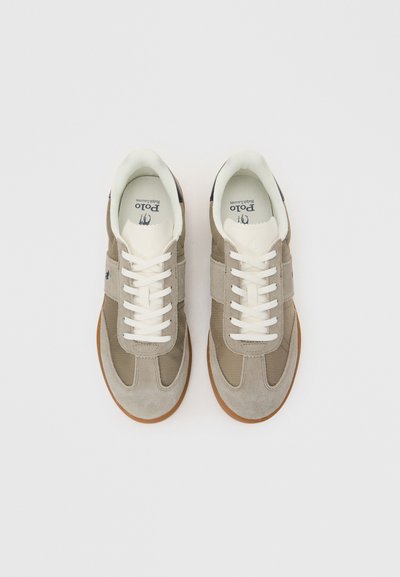 Ζευγάρι μπεζ και γκρι αθλητικά παπούτσια Polo Ralph Lauren με λευκά κορδόνια και καουτσούκ σόλες, σε λευκό φόντο, φωτογραφημένα από πάνω.