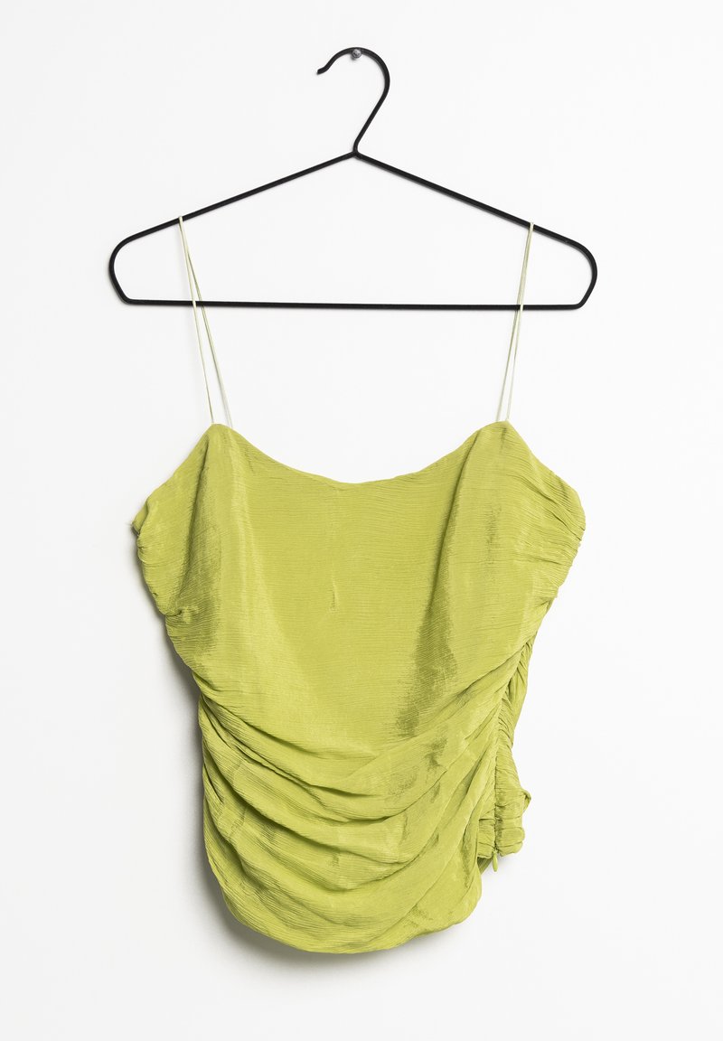 Grøn, tekstureret top med justerbare spaghetti-stropper, med en design af samlet stof og en flæset kant. Hænger fra en sort metalbøjle.