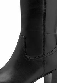 Sorte læderknæhøje støvler med en glat overflade, der har en elastisk sidepanel og en robust blokhæl. Tydelige syninger er synlige.