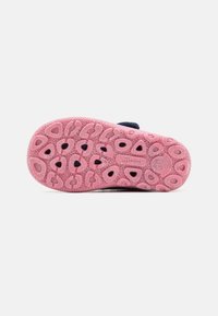 Barnslippersula, rosa gummi med texturerade greppmönster och utskärningar, med en slät marinblå överdel och flexibel design.