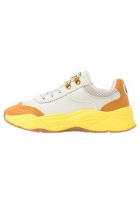Sneaker with a cream upper, orange accents, and a yellow chunky sole. Features mesh sides, round laces, and gold-tone eyelets.