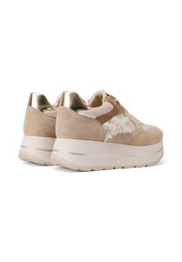 Sneakers platform beige con dettagli in suede e pelliccia sintetica, dettaglio sul tallone metallico e superficie texturizzata. Forma arrotondata con leggero rialzo.