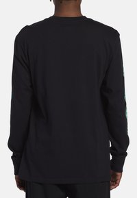 Sort langærmet t-shirt med rund hals, der har farverige prints langs ærmerne. Fremstillet af et glat, let bomuldsstof.