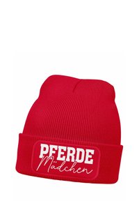 Red knit beanie with a folded cuff, featuring a rectangular patch that reads "PFERDE Mädchen" in white lettering, smooth texture.