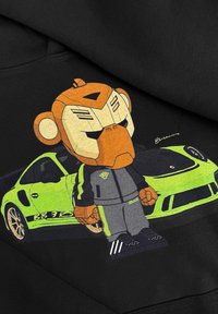 Zwarte hoodie met een cartoonfiguur met een oranje aapshoofd, gekleed in een grijze outfit, naast een felgroene sportauto.